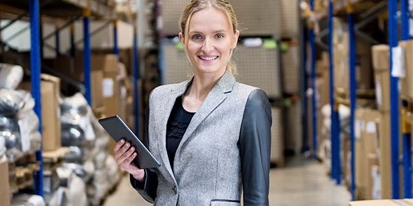 Email topbillede 300x600 Businesswoman holding tablet and smiling in warehouse